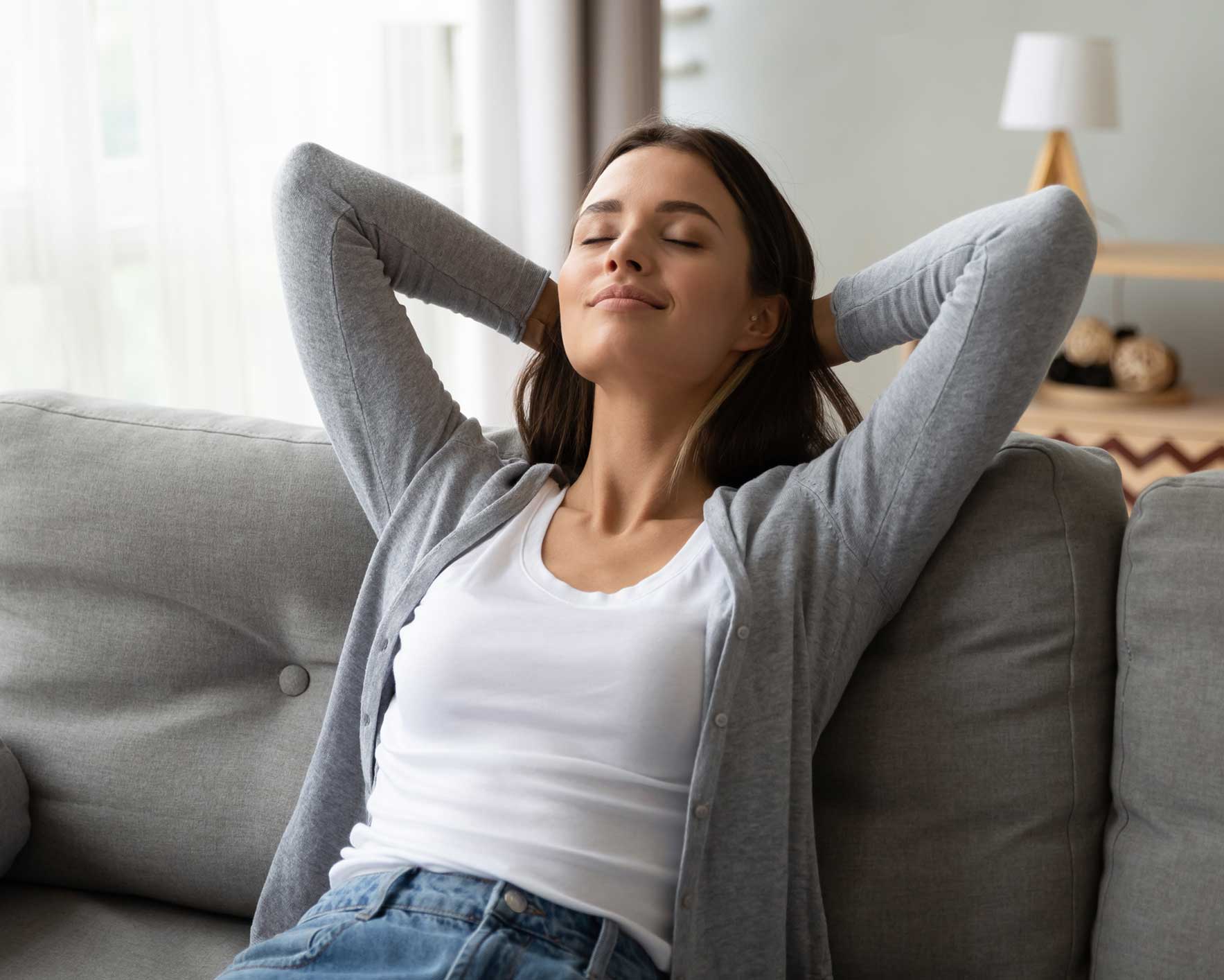 Relaxed serene young woman lounge on comfortable sofa at home